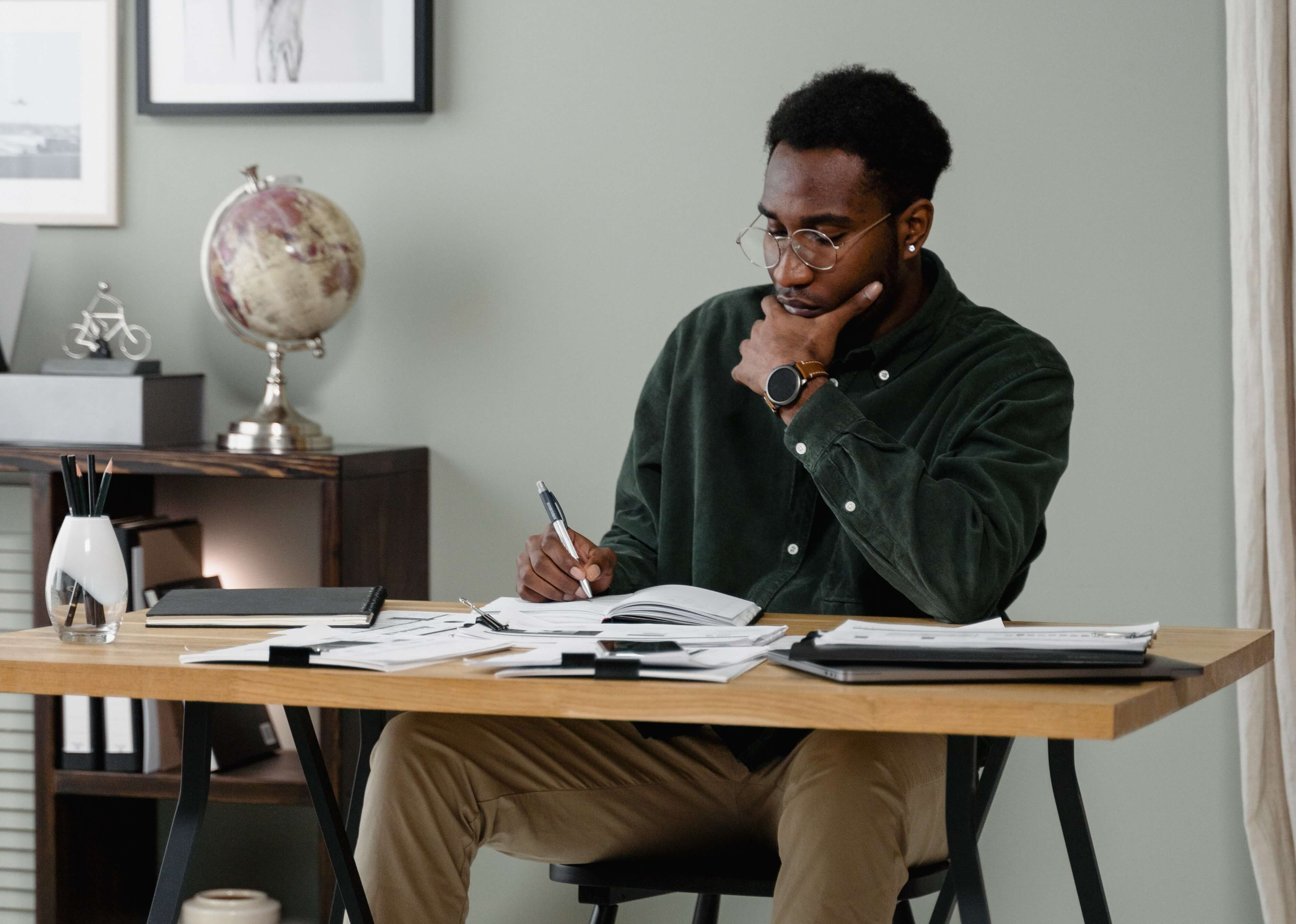 man sitting at desk writing